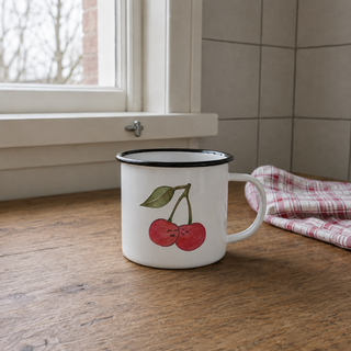 Ligarti emaille mok Kers 300 ml op een houten keukentafel bij het raam.