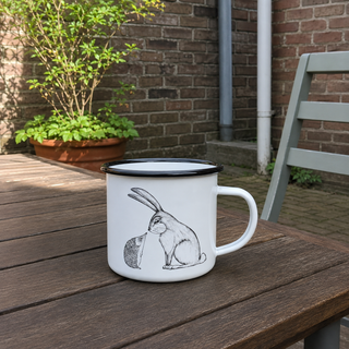 Ligarti emaille mok Konijn & Egel 300 ml op een houten tafel in een rustige binnentuin.