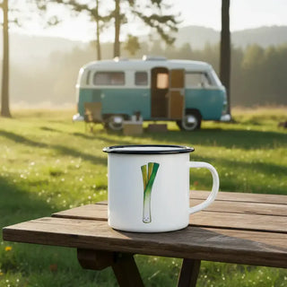 Ligarti emaille mok Prei (300 ml) op een houten picknicktafel met een blauw-witte camper op de achtergrond.