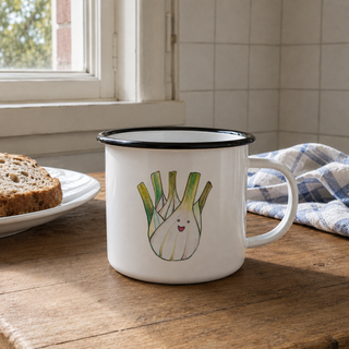 Ligarti emaille mok Venkel 300 ml bij een gewone keukentafel met katoenen theedoek en zacht strijklicht langs het emaille.