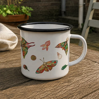 Detail van Handgemaakte emaille mok bonte motten 300ml, met zicht op de illustratie en het glanzende emaille.