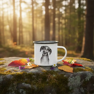 Witte emaille mok met hondenillustratie op een met mos begroeide steen in het bos