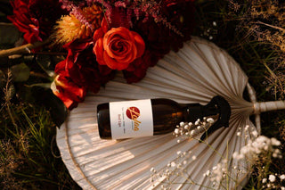 Fles Red Lips luchtverfrisser met bloemen en palmblad, natuurlijke sfeer