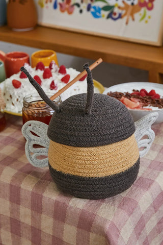 Kleine bijenmand op een gedekte tafel.