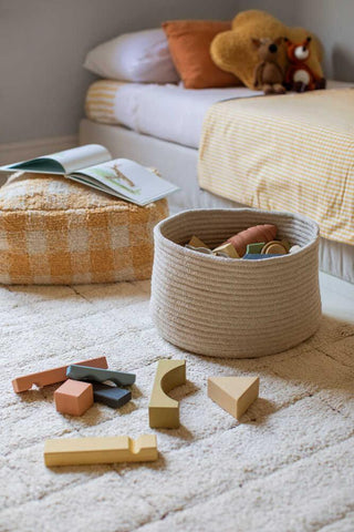 Lorena Canals Gram Natural mand met blokken naast een bank