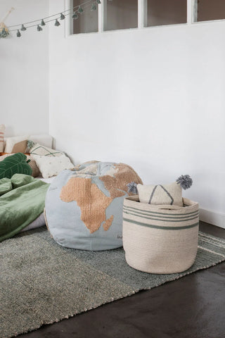 Twin-mand met vintageblauwe strepen bij een bed en een bolvormige poef.