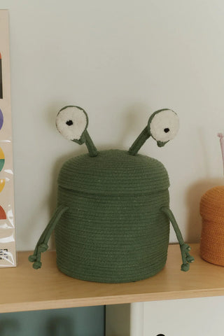 Groene alienmand met twee ogen op een plank.