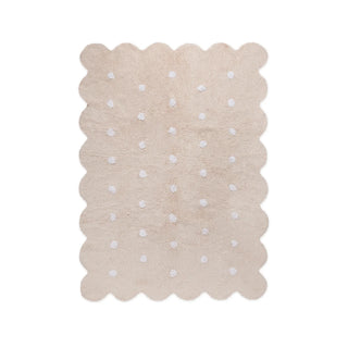 Beige vloerkleed met lichte stippen en golvende rand.