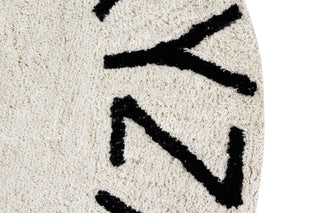 Detail van de naturel textuur en zwarte letters van het ABC-vloerkleed.