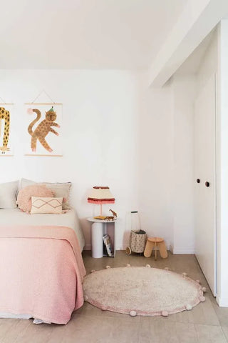 Bubbly vloerkleed met roze rand naast een bed