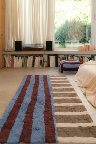 Blauw-bordeaux Color On-loper naast een bed.