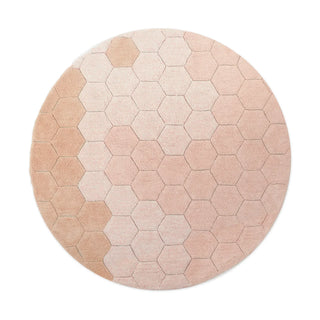 Rond roze honingraatvloerkleed.