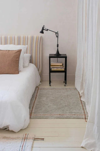 Cloth Blue Sage vloerkleed naast een bed