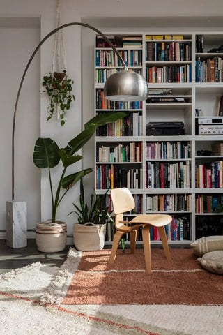 Duetto Toffee-vloerkleed bij een stoel en boekenkast.
