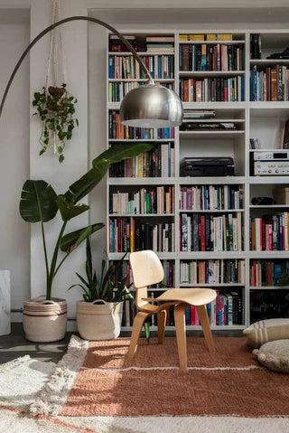 Duetto Toffee-vloerkleed bij een stoel en boekenkast.