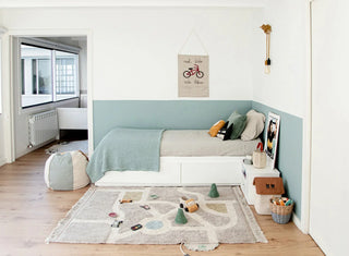 Eco-City-speelkleed met wegenpatroon en speelgoed in een kinderkamer.