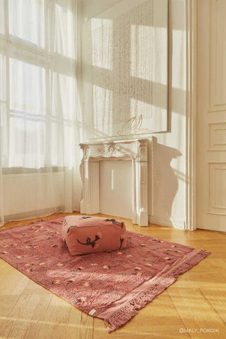 English Garden Ash Rose vloerkleed bij een poef in een lichte kamer
