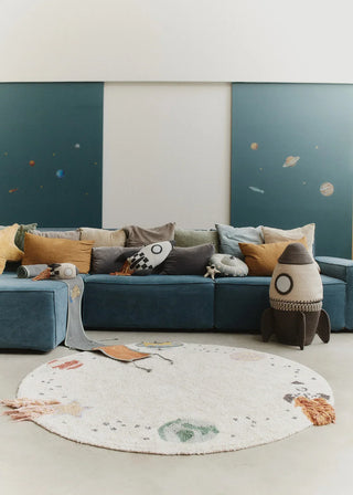 Rond Interstellar-vloerkleed voor een blauwe bank.