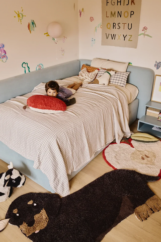 Hondvormig Jack-vloerkleed voor een bed in een kinderkamer.