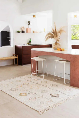 Naturel vloerkleed met ruiten naast een keukenbar.