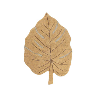 Monstera-vloerkleed in honingkleur, in bladvorm met steel. Op witte achtergrond.