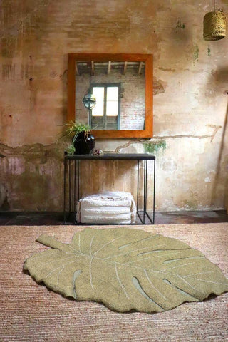 Monstera Olive vloerkleed voor een houten tafel