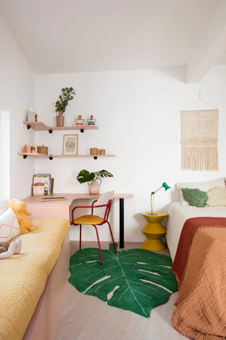 Groen bladvloerkleed naast een bed en bureau.