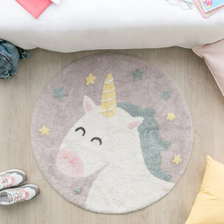 Rond eenhoornvloerkleed voor een bed.