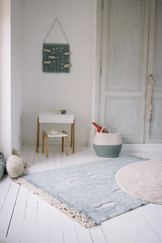 Blauw vloerkleed met lichte vismotieven in een kamer.