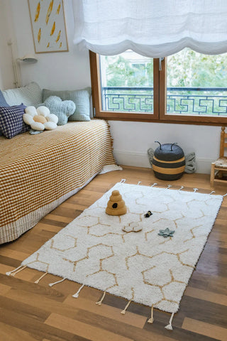 Speelvloerkleed met honingraatpatroon en losse speelelementen.