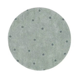 Rond blauwgroen vloerkleed met blauwe stippen.
