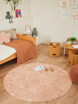 Roze gestippeld vloerkleed in een kinderkamer.
