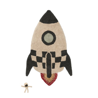 Raketvormig vloerkleed met donkere motieven en losse astronautfiguur.