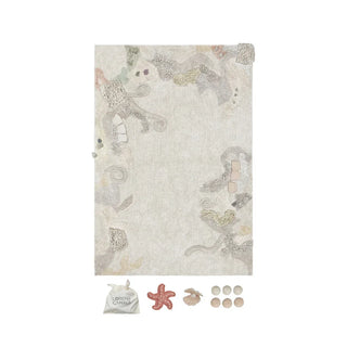 Seabed-speelkleed met zeemotief en losse accessoires eronder. Op witte achtergrond.