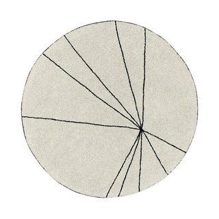 Rond naturel Trace-vloerkleed met zwarte lijnen op witte achtergrond.