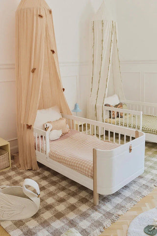 Lorena Canals Vichy Marron geruit vloerkleed bij een kinderbed