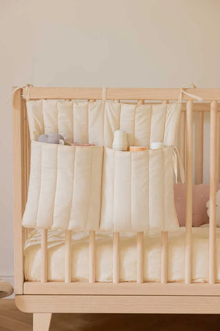 Naturelkleurige opberghanger aan een houten ledikant