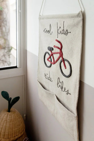 Wandhanger met fiets en opbergvakken naast een raam.
