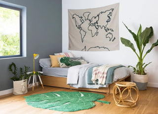 Wereldkaartwanddecoratie boven een bed.