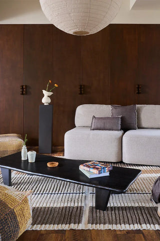 Lorena Canals Columns Natural vloerkleed bij een grijze bank