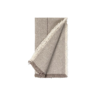 Eén gevouwen greigekleurige servet uit de set van 4, met franjes; één exemplaar uit de set.