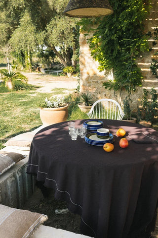 Donkerbruin Handloom-tafelkleed over een ronde tuintafel.