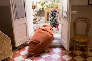 Kind trekt een wortelvormige zitzak aan het groene loof.