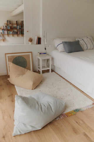 Cleo Natural poef naast een bed