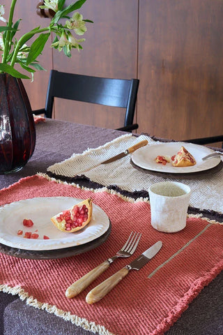 Vertical-placemat in naturel met bord en bestek op een gedekte tafel.
