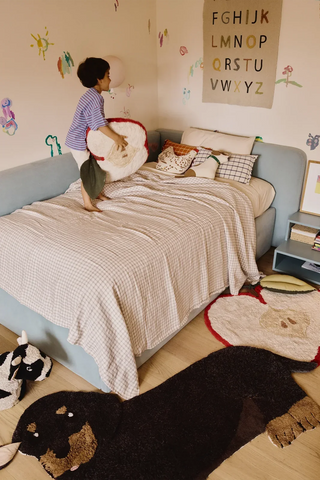 Appelkussen op een bed in een kinderkamer.