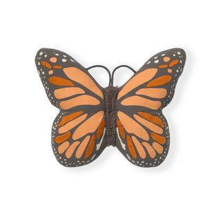 Vlinderkussen met zwarte, oranje en roze vleugels en witte stippen.