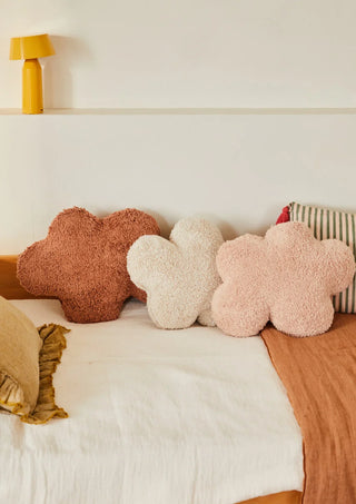 Wolkkussens in bruin, naturel en roze naast elkaar op een bed.