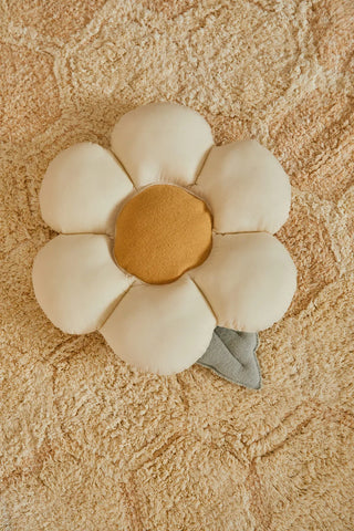 Licht bloemkussen op een honingraatvloerkleed.
