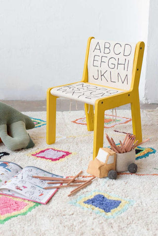 ABC-canvas op een gele kinderstoel